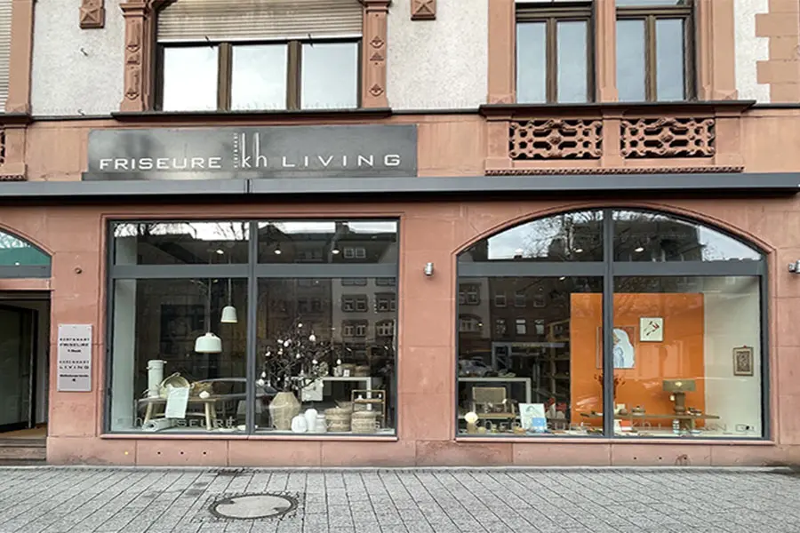 Schaufenster eines Friseursalons mit Wohnaccessoires im modernen Stil in der Innenstadt.